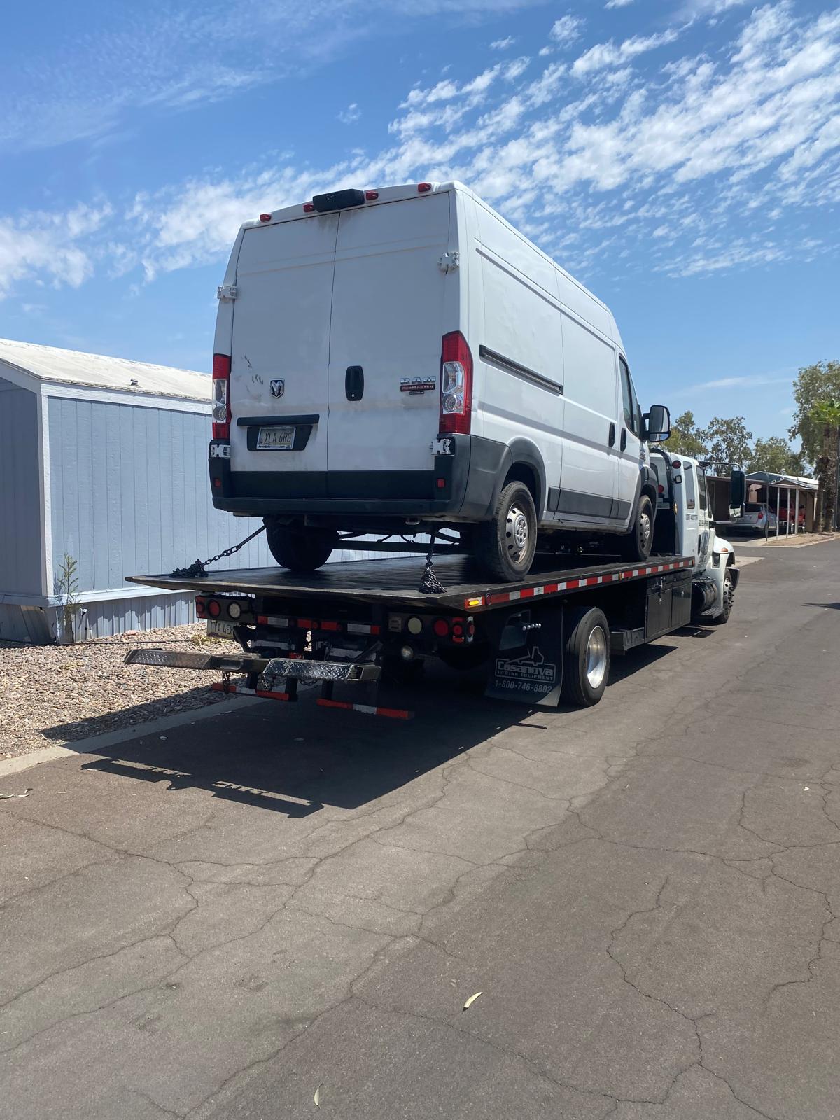 Cargo van secured on a flatbed tow truck